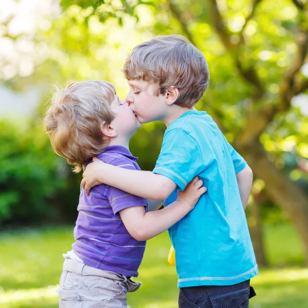 Twee kleine broer of zus jongens knuffelen en hebbend pret buitenshuis — Stockfoto
