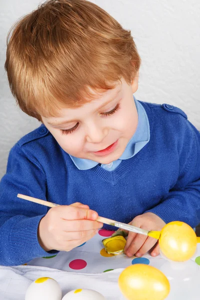 Polowanie na trochę maluch chłopiec malarstwo kolorowe jajka na Wielkanoc — Zdjęcie stockowe