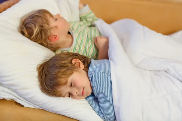Дві маленькі блондинки хлопчики-сестри сплять у ліжку — стокове фото