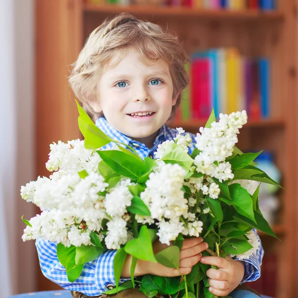 Bedårande liten barn pojke med blommande vit lila blomma — Stockfoto