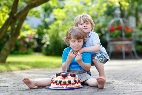 Dos niños pequeños divirtiéndose juntos con un gran pastel de cumpleaños —  Fotos de Stock