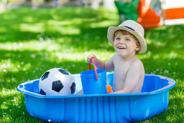 Piccolo bambino ragazzo si diverte con spruzzi d'acqua in estate gar — Foto Stock