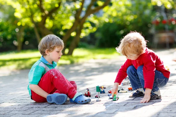 Två kid lite pojkar leker med bil leksaker — Stockfoto