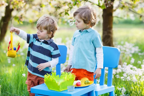 Deux petits garçons jouent et peignent des œufs colorés — Photo