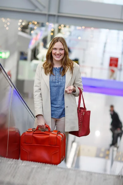 Kvinna på internationella flygplats, på rulltrappan på ankomst terminalen — Stockfoto