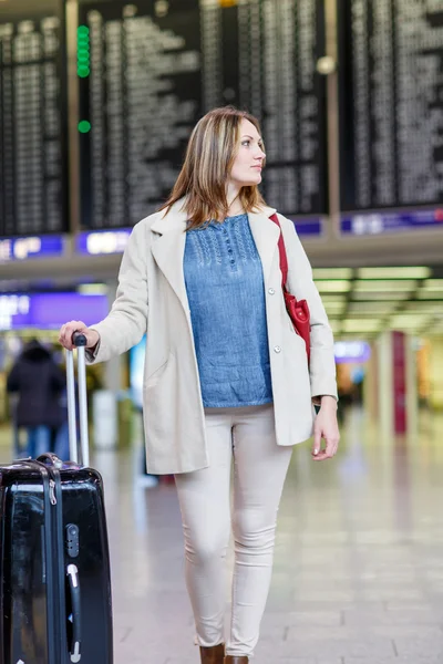 Mujer joven en el aeropuerto internacional, control de tablero electrónico — Foto de Stock