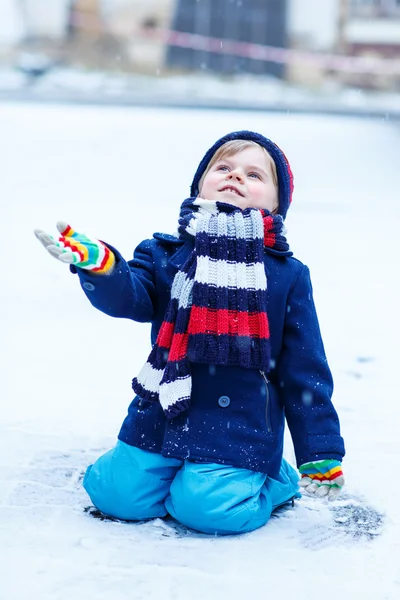 Carino poco divertente ragazzo in colorato inverno vestiti avendo divertimento con — Foto Stock