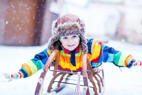 Cute little funny boy in colorful winter clothes having fun with — Stock Photo, Image