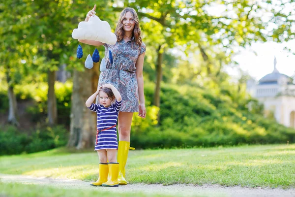Madre y pequeño niño adorable en botas de goma amarillas —  Fotos de Stock