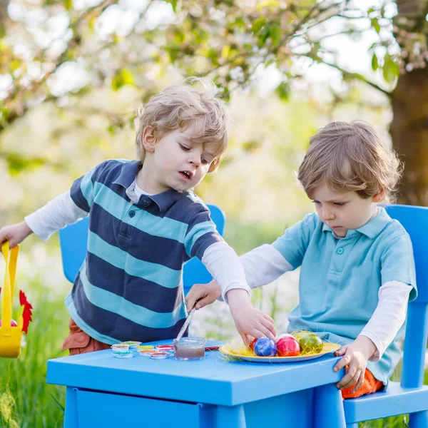 Roliga små pojkar playinig och målning färgglada ägg — Stockfoto