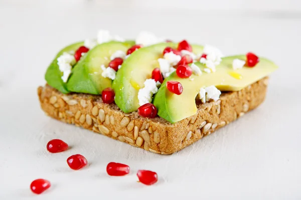 Avocado met Feta, granaatappel op zonnebloempitten brood broodje — Stockfoto