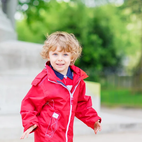 Cute little  boy catching and playing with pigeons in city — Stock Photo, Image