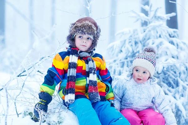 Portrait of two kids: boy and girl in winter hat in snow forest — Stock Photo, Image