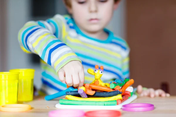 Kezében kis gyerek játszik a tésztát, színes, modellezés kötelező — Stock Fotó