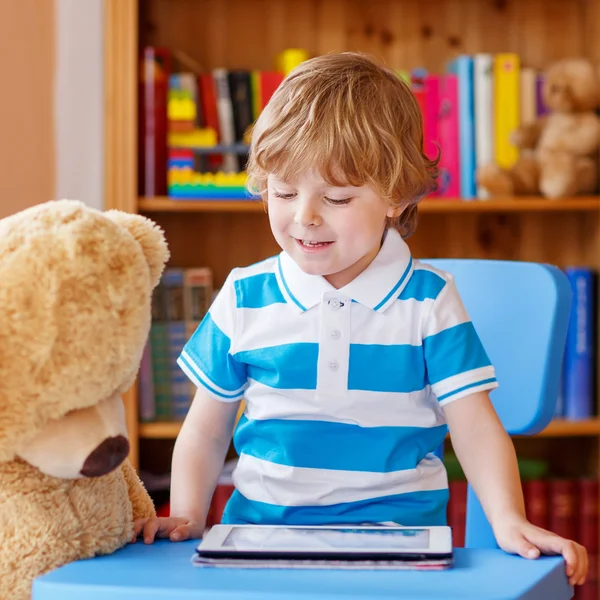 Cute preschool boy playing with tablet computer in his room at h — Stock Photo, Image