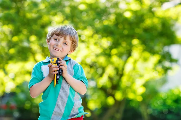 Liten unge pojke leker med bil leksak, utomhus — Stockfoto