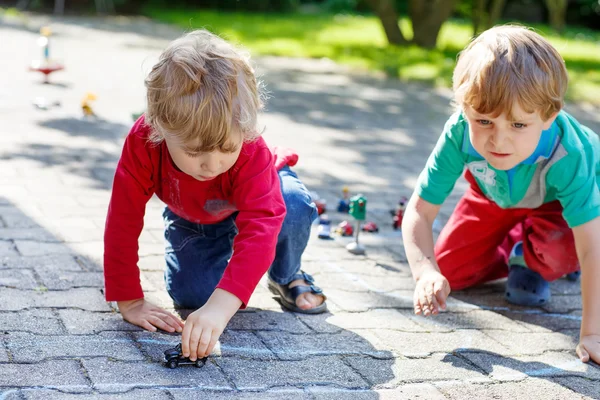 2 つは小さな車のおもちゃで遊ぶ男の子たちを子供します。 — ストック写真