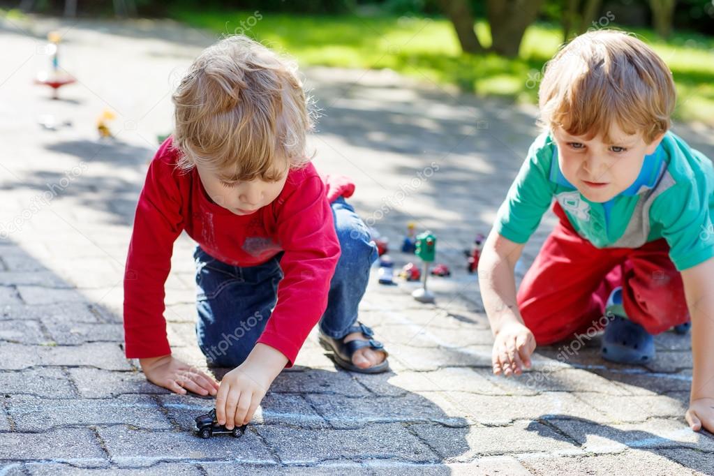 Two little kid boys playing with car toys