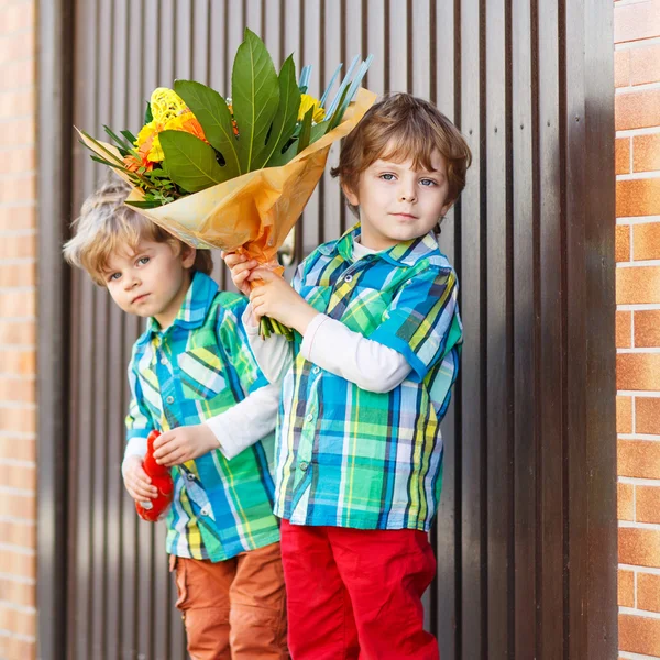 Two happy adorable little sibling boys with blooming  flowers — Stock Photo, Image