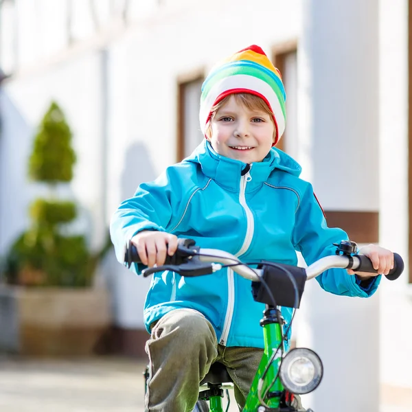 Pequeno menino pré-escolar montando com sua primeira bicicleta verde — Fotografia de Stock