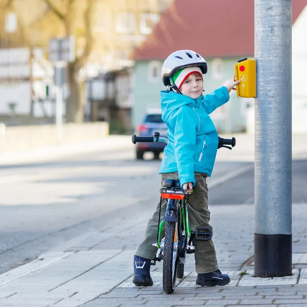 Petit garçon d'âge préscolaire chevauchant avec son premier vélo vert — Photo