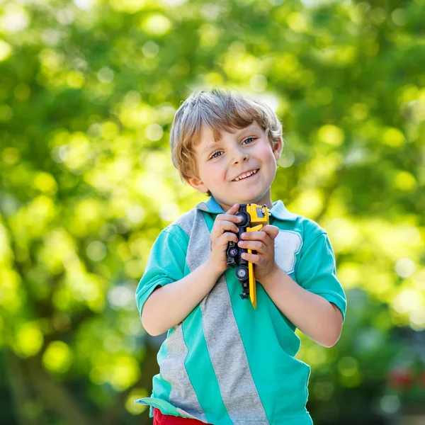 Kleiner Junge spielt mit Autospielzeug, im Freien — Stockfoto