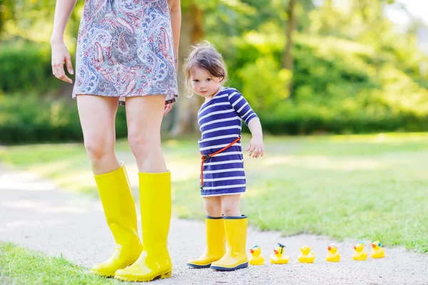 Madre e piccolo adorabile bambino in stivali di gomma gialla — Foto Stock