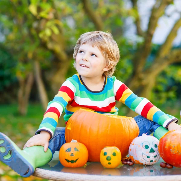 Little kid boy making jack-o-lantern for halloween in autumn gar — Stock Photo, Image