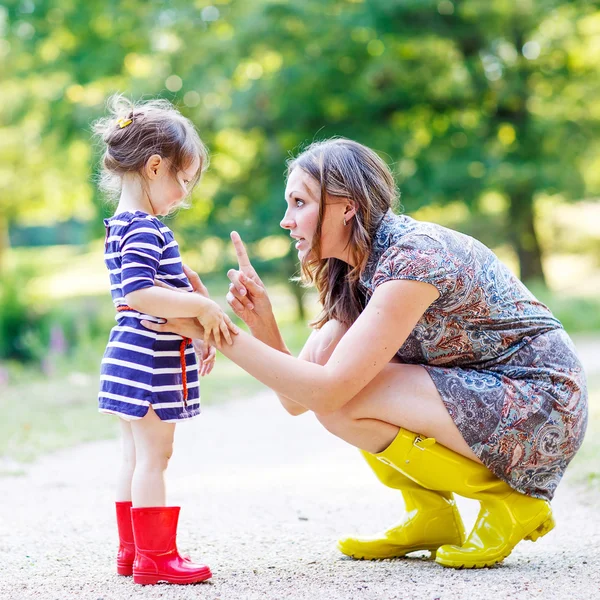 Mother and little adorable child in yellow rubber boots — Stock Photo, Image