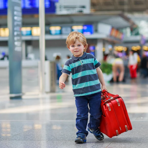 Mały chłopiec będzie na wyjazd wakacje walizka na lotnisku — Zdjęcie stockowe