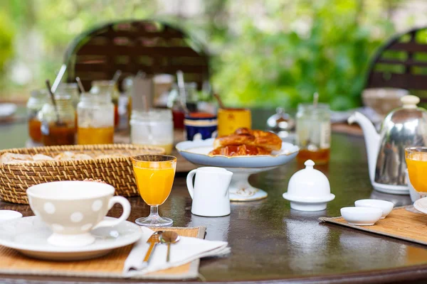 Table posée pour le petit déjeuner à l'extérieur avec diverses confitures café, crois — Photo