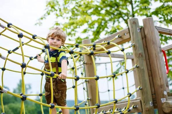 Netter Junge hat Spaß beim Klettern auf Kinderspielplatz — Stockfoto