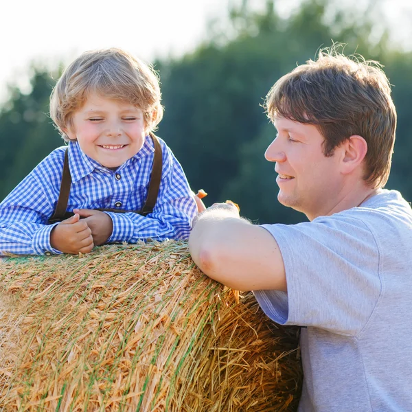 Jeune père et son petit fils s'amuser sur le champ de foin jaune i — Photo