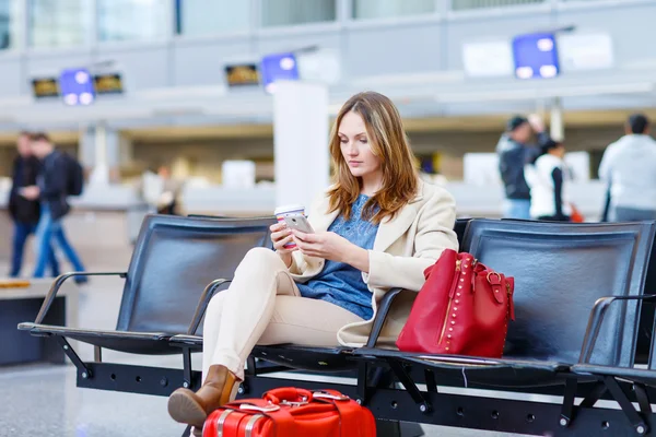Kvinna på internationella flygplatsen, läsa e-bok och dricka kaffe — Stockfoto