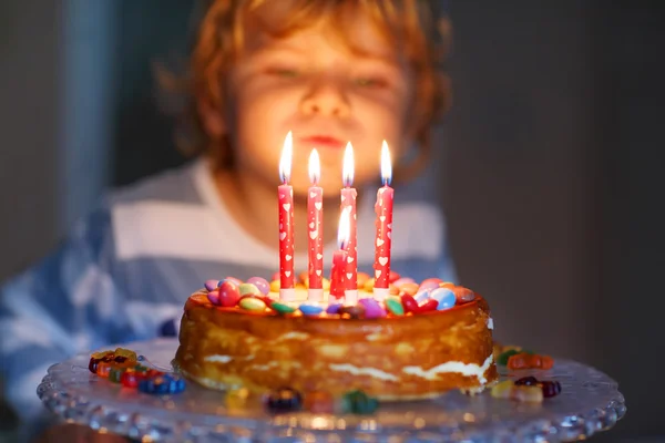 Kid boy celebrating his birthday and blowing candles on cake — Stock Photo, Image