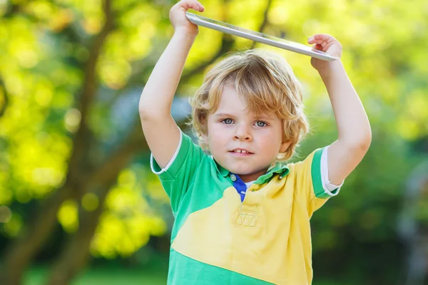 Adorable happy little kid boy holding tablet pc, outdoors — Stock Photo, Image