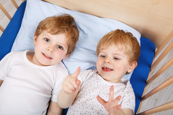 Irmãozinho meninos se divertindo na cama em casa — Fotografia de Stock