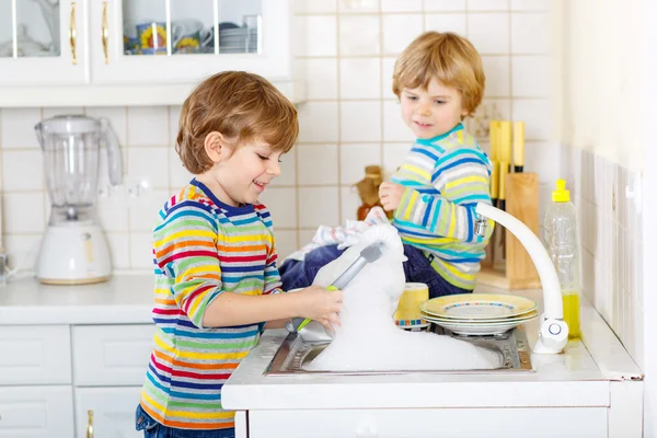 Two little blond kid boys washing dishes in domestic kitchen — Stock Photo, Image
