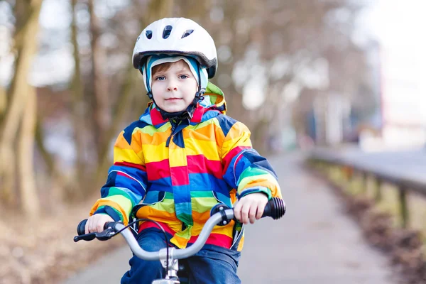 Παιδί αγόρι στο κράνος ασφαλείας και πολύχρωμο αδιάβροχο ιππασία ποδήλατο, εξωτερικούς χώρους RCES005 — Φωτογραφία Αρχείου