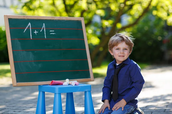 Petit garçon au tableau noir pratiquant les mathématiques — Photo