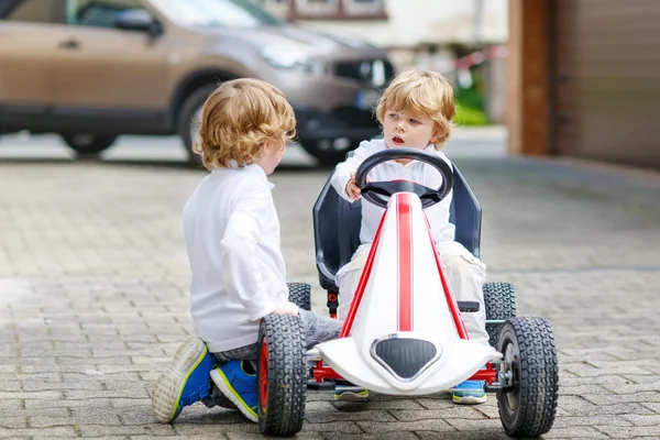 Due felici fratelli ragazzi che giocano con la macchina giocattolo — Foto Stock