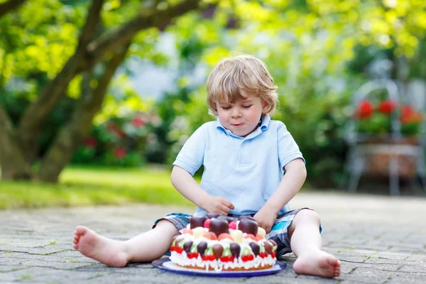 Little boy celebrating his birthday in home's garden with big ca — Stock Photo, Image