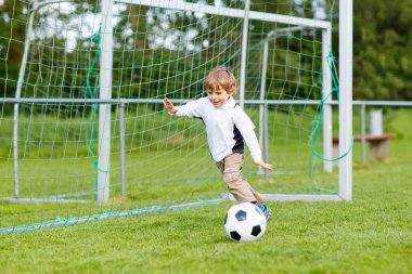 Futbol ve futbol sahasında oynayan iki küçük kardeş erkek