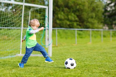 Futbol ve futbol sahasında oynayan iki küçük kardeş erkek