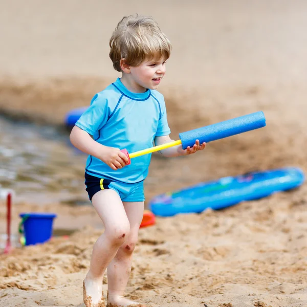 Little toddler boy having fun with splashing water near city lak — Stock Photo, Image