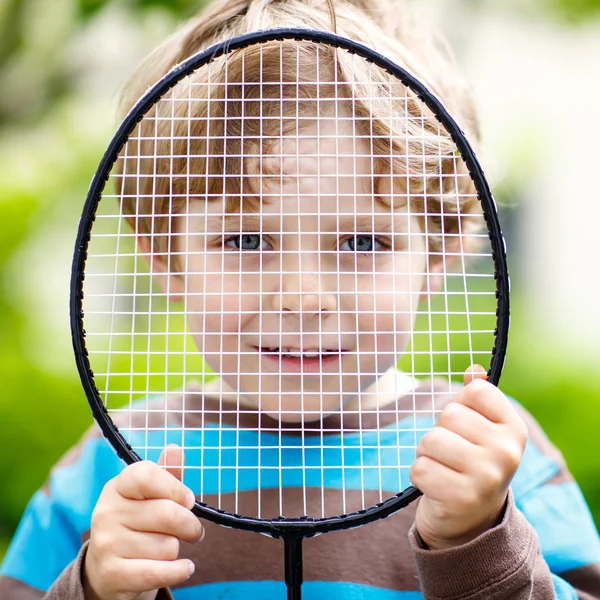 Kleiner lustiger Junge spielt Badminton im heimischen Garten — Stockfoto