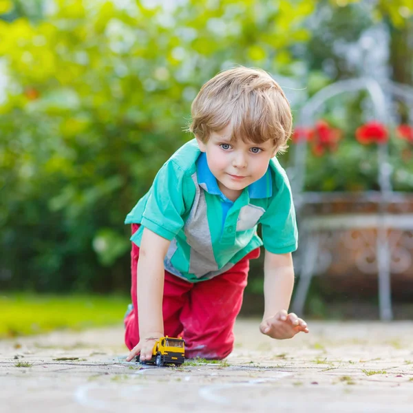 Liten unge pojke leker med bil leksak, utomhus — Stockfoto