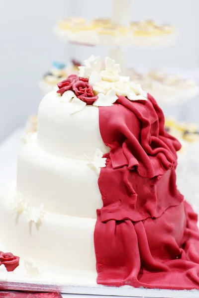Bröllopstårta i vitt och vin röd med blommor — Stockfoto