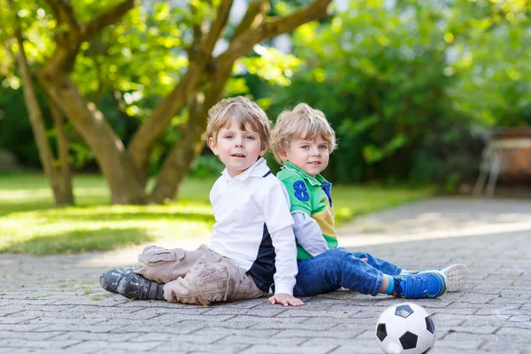 两个小兄弟男孩踢足球和足球 — 图库照片