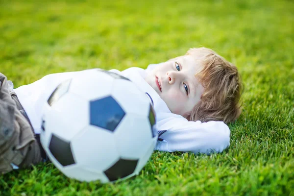 4 ile futbol futbol sahasında oturan sarışın çocuk — Stok fotoğraf